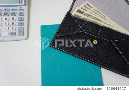 A calculator on a desk and a wallet with a 10,000 yen note A calculator on a desk and a wallet with a 10,000 yen note 126941627