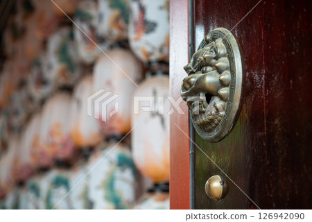 A Chinese Door with a Decorative Knocker and Traditional Lantern 126942090