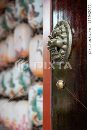 A Chinese Door with a Decorative Knocker and Traditional Lantern 126942092