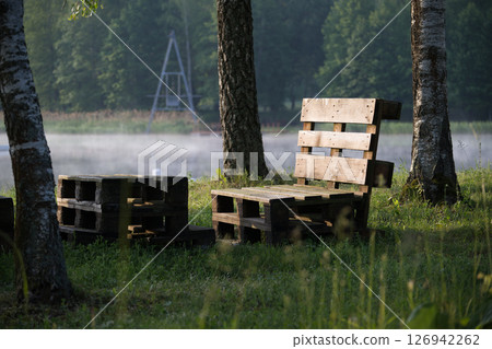 Rustic Wooden Chair Made of Pallets Against a Tranquil Forest Backdrop 126942262