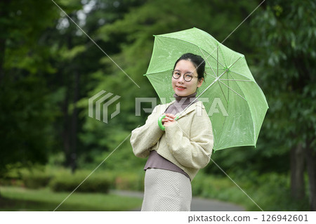 Smiling Japanese woman holding an umbrella 126942601