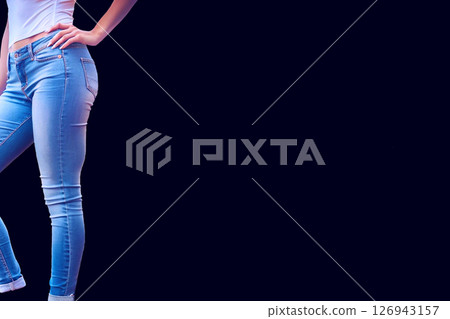 Beautiful female legs in blue jeans on black 126943157