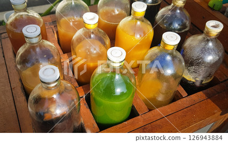 Colorful Bottles of traditional natural organic medicine locally called jamu, Displayed in Wooden Case on a Sunny Day 126943884