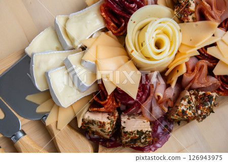 Wooden charcuterie cheese board holiday present idea. Snack starter plate for dinner with wine. Italian appetizers or antipasto set with gourmet food. Buffet party Wooden charcuterie cheese board holiday present idea. Snack starter plate for dinner with wine. Italian appetizers or antipasto set with gourmet food. Buffet party 126943975