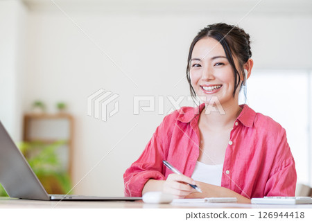 A young woman doing telework in the living room. 126944418