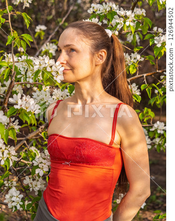 Beautiful Young woman without makeup in a spring park among flowering trees 126944502