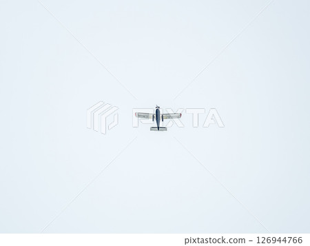 Small ultralight airplane with overhead wing and single propeller flying in sunset sky. Small ultralight airplane with overhead wing and single propeller flying in sunset sky. 126944766