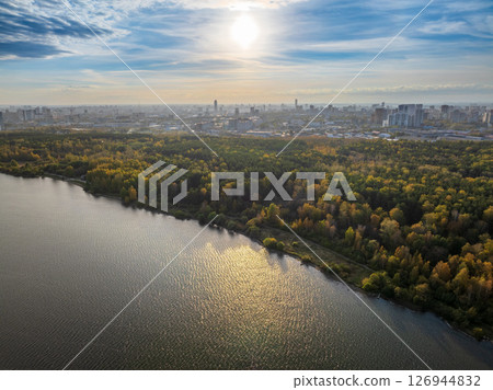 Autumn forest on lake shore at sunset and city on horizon, auerial view Autumn forest on lake shore at sunset and city on horizon, auerial view 126944832