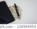 Wallet. A long wallet and 10,000 yen bills on a desk. 126944954