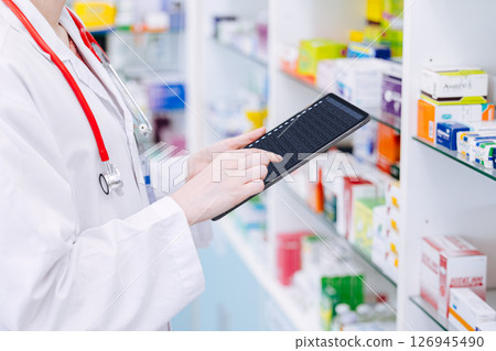 Pharmacist working, Druggist doctor using tablet computer to check drug detail in stock smart device 126945490