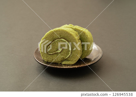 在黑色背景下格外醒目的抹茶捲蛋糕 126945538