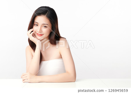 A beautiful young Asian woman with clean, fresh skin against a white background. Skincare, facial treatment, cosmetology, beauty, and spa. An elegant portrait of an Asian woman. 126945659