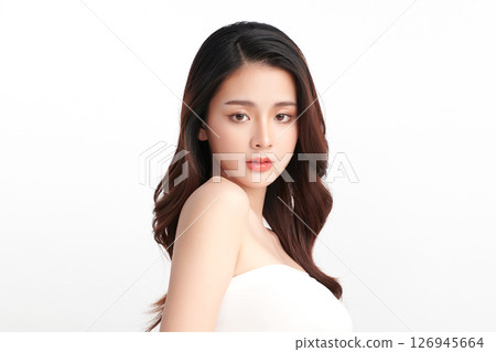 A beautiful young Asian woman with clean, fresh skin against a white background. Skincare, facial treatment, cosmetology, beauty, and spa. An elegant portrait of an Asian woman. 126945664