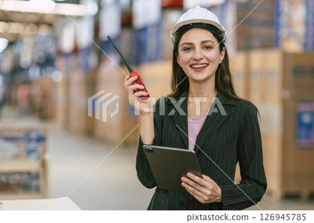 portrait smart logistics business women, female worker with white helmet control stock in warehouse 126945785