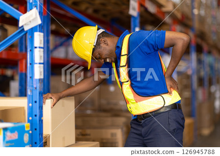 worker back pain, african male worker working in warehouse storage suffering from muscle problem 126945788