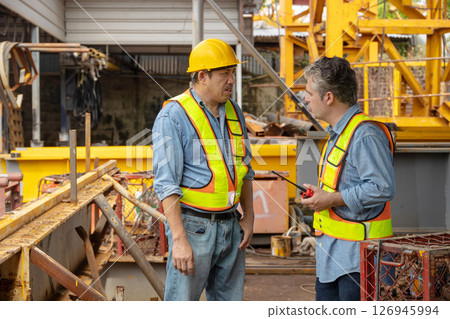 Construction engineer team working together join teamwork talking together at construction site 126945994