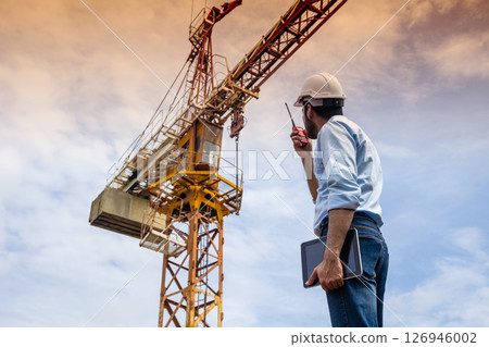 Hispanic Indian professional construction engineer working operate Crane hoist in construction site Hispanic Indian professional construction engineer working operate Crane hoist in construction site 126946002
