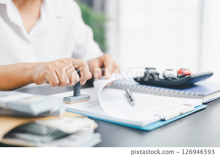 Businesswoman hand stamp approve on financial business approval document paper. Man hand accept permit contract agreement. Broker manager sign contract bank guarantee approved stamp application form 126946593