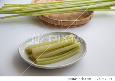 Raw butterbur and boiled butterbur on a white plate 126947073