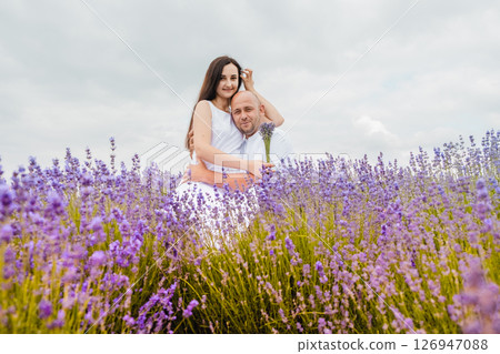 A couple in love embraces in a purple field of flowers 126947088