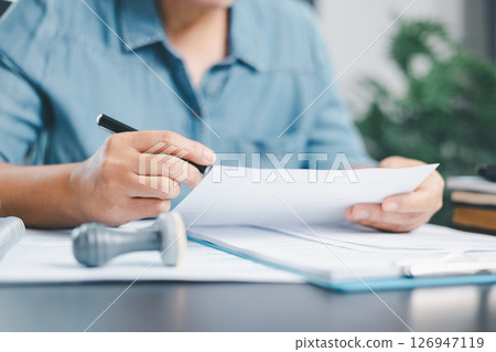 Businessman hands stamp approve on financial business approval document paper. Man hand accepted permit contract agreement. Broker manager sign contract bank guarantee approved stamp application form 126947119