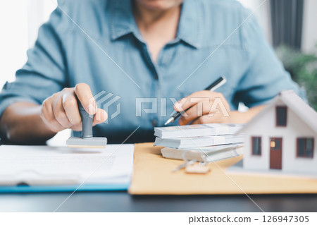Businesswoman hand stamp approve on financial business approval document paper. Man hand accept permit contract agreement. Broker manager sign contract bank guarantee approved stamp application form 126947305