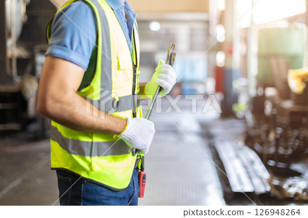 closeup engineer worker ready to service with wrench in safety suit standing with copyspace for text 126948264