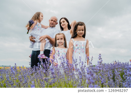 The lavender field surrounds the family with its magical atmosphere The lavender field surrounds the family with its magical atmosphere 126948297