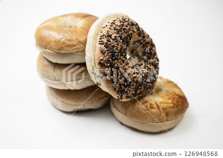 Closeup view of stack collection of bagel breads with various kind isolated over white background Closeup view of stack collection of bagel breads with various kind isolated over white background 126948568