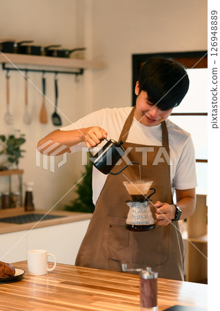 Man preparing freshly brewed coffee using a drip method at home Man preparing freshly brewed coffee using a drip method at home 126948889