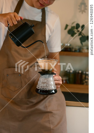 Man preparing freshly brewed coffee using a drip method at home 126948895