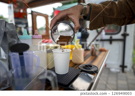 Male barista serving coffee at a table. A small business of a coffee shop or cafe on a truck 126949003