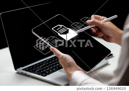 Businesswoman using a tablet with an invoice and mail icon. Laptop on the table. Technology innovation on a virtual screen. Concept of E-invoice and online digital statements Businesswoman using a tablet with an invoice and mail icon. Laptop on the table. Technology innovation on a virtual screen. Concept of E-invoice and online digital statements 126949020