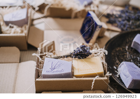 Lavender and yellow handmade soaps with stamped logos placed in kraft boxes with dried flowers. Handmade soap, artisanal branding, logo stamping, small batch production 126949923