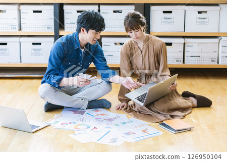 Man and woman sitting on the office floor 126950104