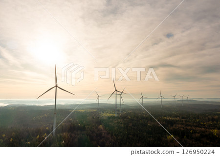 Aerial view with wind turbines farm inside a forest at sunrise 126950224