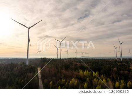 Drone aerial view with wind turbines farm inside a forest at sunrise 126950225