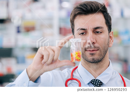 Doctor Pharmacist man in drug store looking hand holding medicine capsule pills pack, Medicare service 126950293