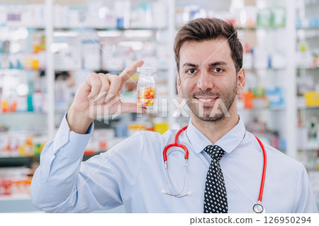Happy Doctor Pharmacist man in drug store hand holding medicine capsule pills pack, Medicare service Happy Doctor Pharmacist man in drug store hand holding medicine capsule pills pack, Medicare service 126950294