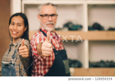 closeup apron man and women wood workshop owner happy smiling thumbs up for good like approve gesture concept closeup apron man and women wood workshop owner happy smiling thumbs up for good like approve gesture concept 126950354