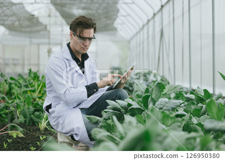 Scientist people working plant research in organic farm. Biologist study collecting plant grow data Scientist people working plant research in organic farm. Biologist study collecting plant grow data 126950380