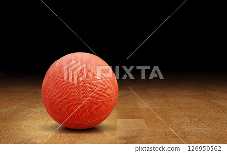 Orange dodgeball on wooden floor, orange rubber ball. 126950562