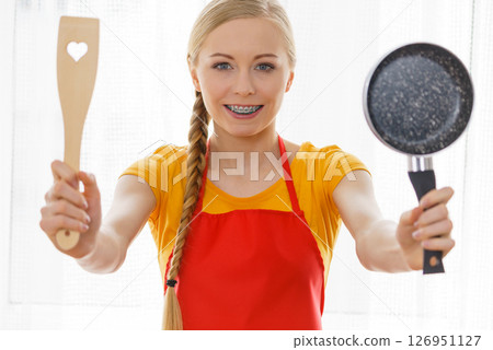 Woman holding cooking utensils 126951127