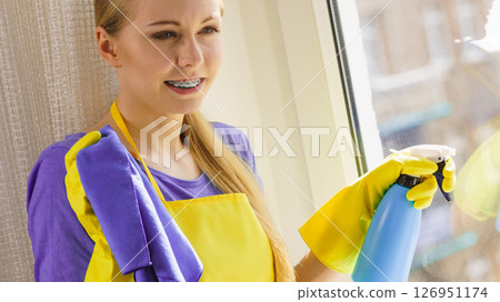 Girl cleaning window at home 126951174