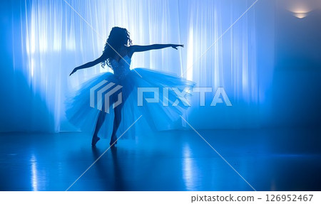 Graceful Ballet Dancer Performing Silhouette Against a Blue Lit Stage 126952467