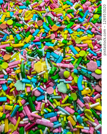 Multicolored small candies of different shapes. Top view. Bright vertical background 126953020