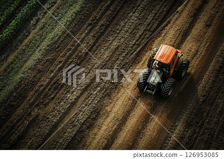 Red tractor driving on plowed field, top view. Agricultural machinery and farming concept. Generated by artificial intelligence 126953085