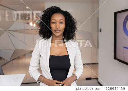 Portrait of African businesswoman stands confidently in modern meeting room 126954439