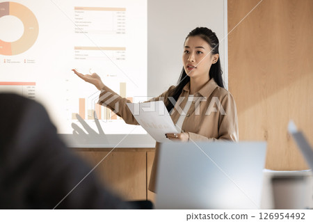 Skilled Asian business coach presenting data to colleagues during seminar Skilled Asian business coach presenting data to colleagues during seminar 126954492