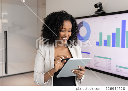 Smiling African woman using tablet in office Smiling African woman using tablet in office 126954528